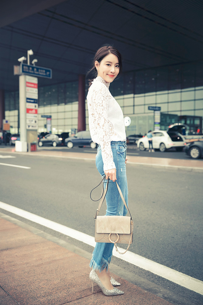 蔡蝶现身机场,低扎马尾配上清爽面容,一袭白色上衣搭配破洞九分牛仔裤