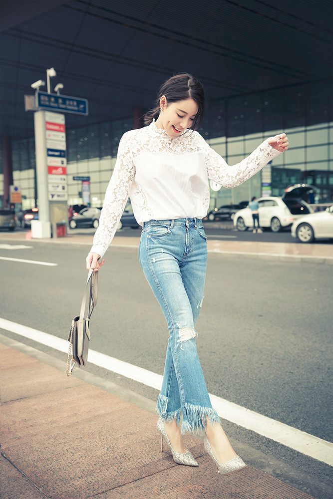 蔡蝶现身机场,低扎马尾配上清爽面容,一袭白色上衣搭配破洞九分牛仔裤