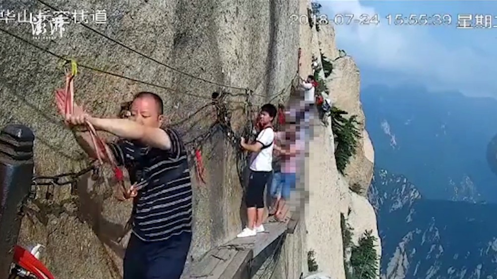 【华山栈道一游客解绳坠崖 景区:仍在搜寻】24日,华山长空栈道,一男子