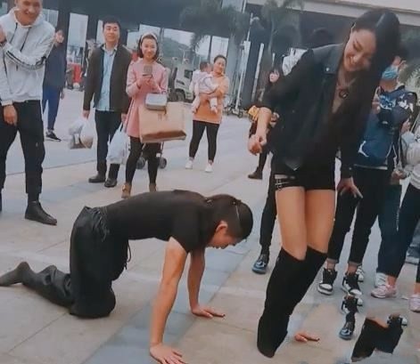 小伙双膝跪地钻美女胯下,随后的事让人傻眼