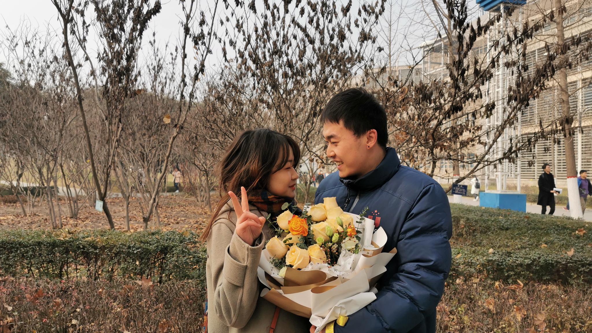 撒狗粮美女手捧鲜花考场外为相爱7年男友加油打气