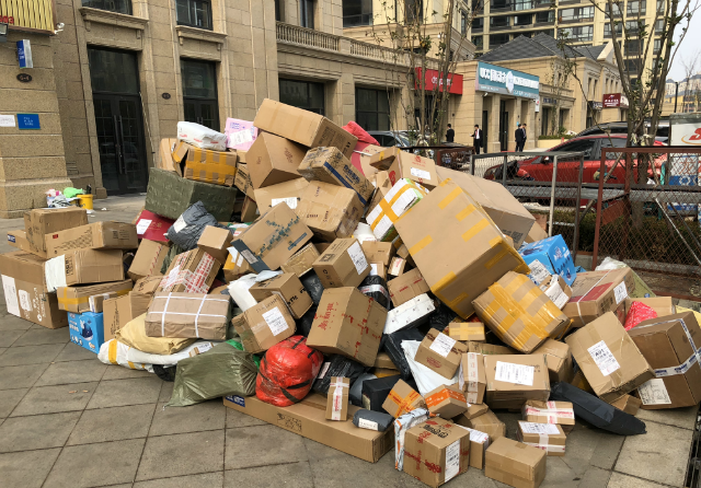 双十一结束快递点上的纸盒堆积如山快递小哥送货全部用扛