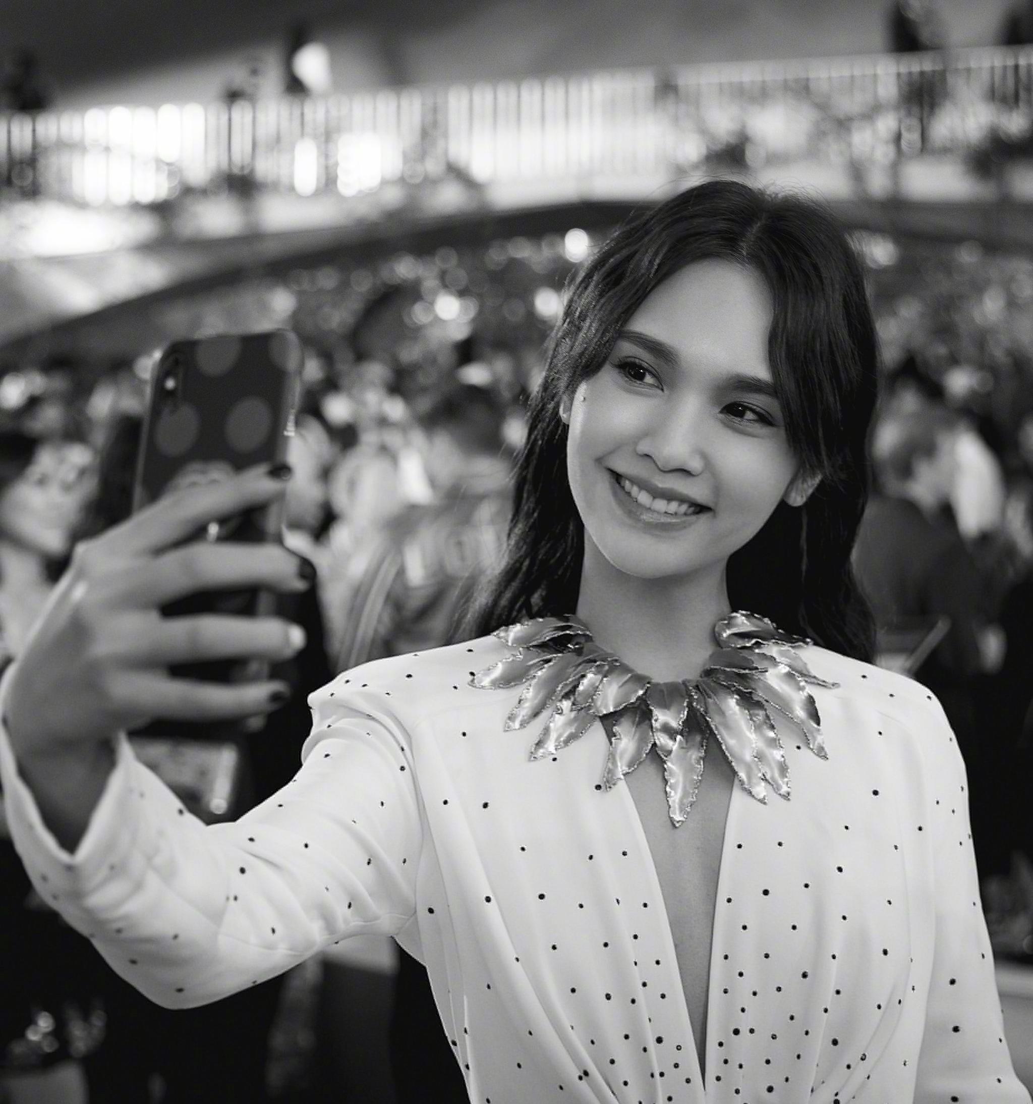 杨丞琳出席某活动,身穿白色深v礼服,戴的金叶子项链,独特别致