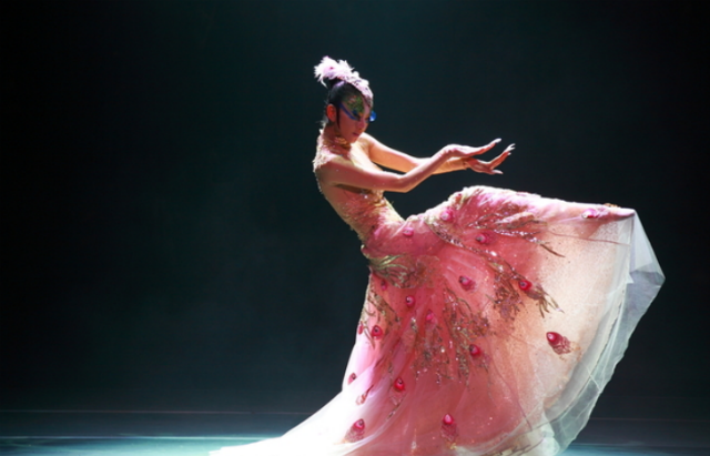 身穿白色的孔雀羽毛做成的裙子,看上去特别漂亮,在镁光灯的照射下