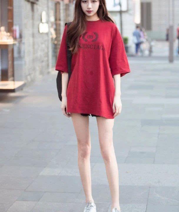 脚踩哪一双白色的帆布鞋,斜挎黑色包包,很