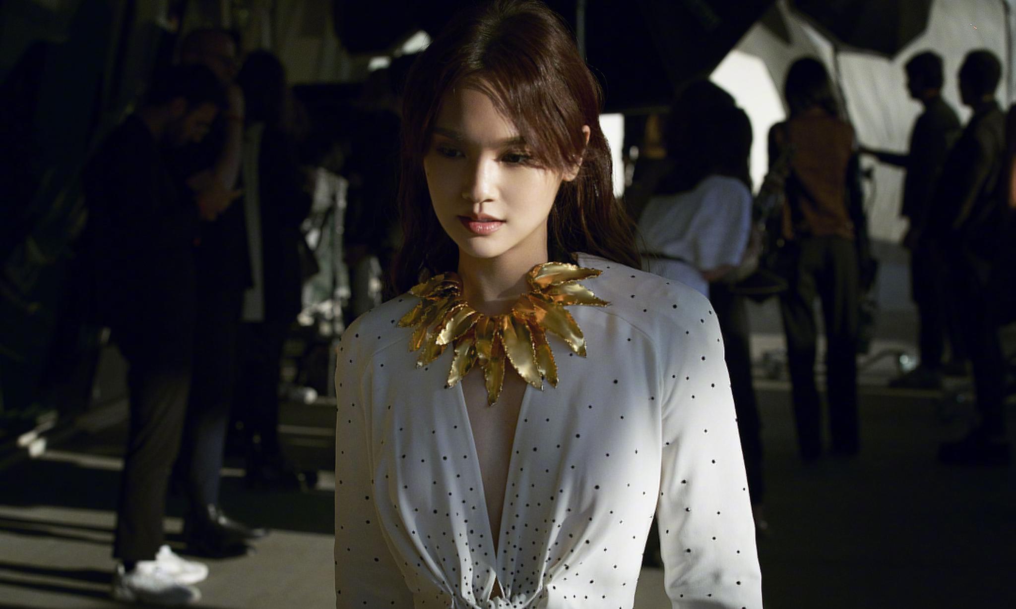 杨丞琳出席某活动,身穿白色深v礼服,戴的金叶子项链,独特别致