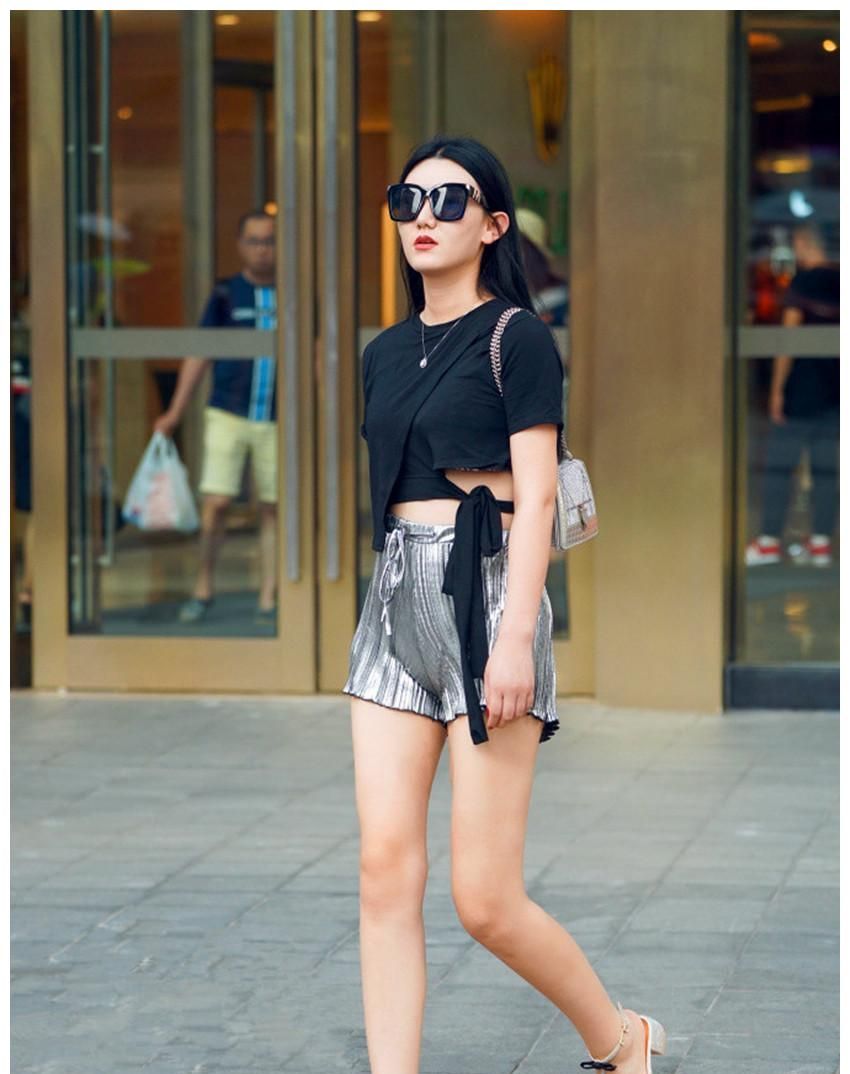 戴墨镜的美女,身穿黑色上衣 短裤,彰显迷人的气质小姐姐身穿白色上衣