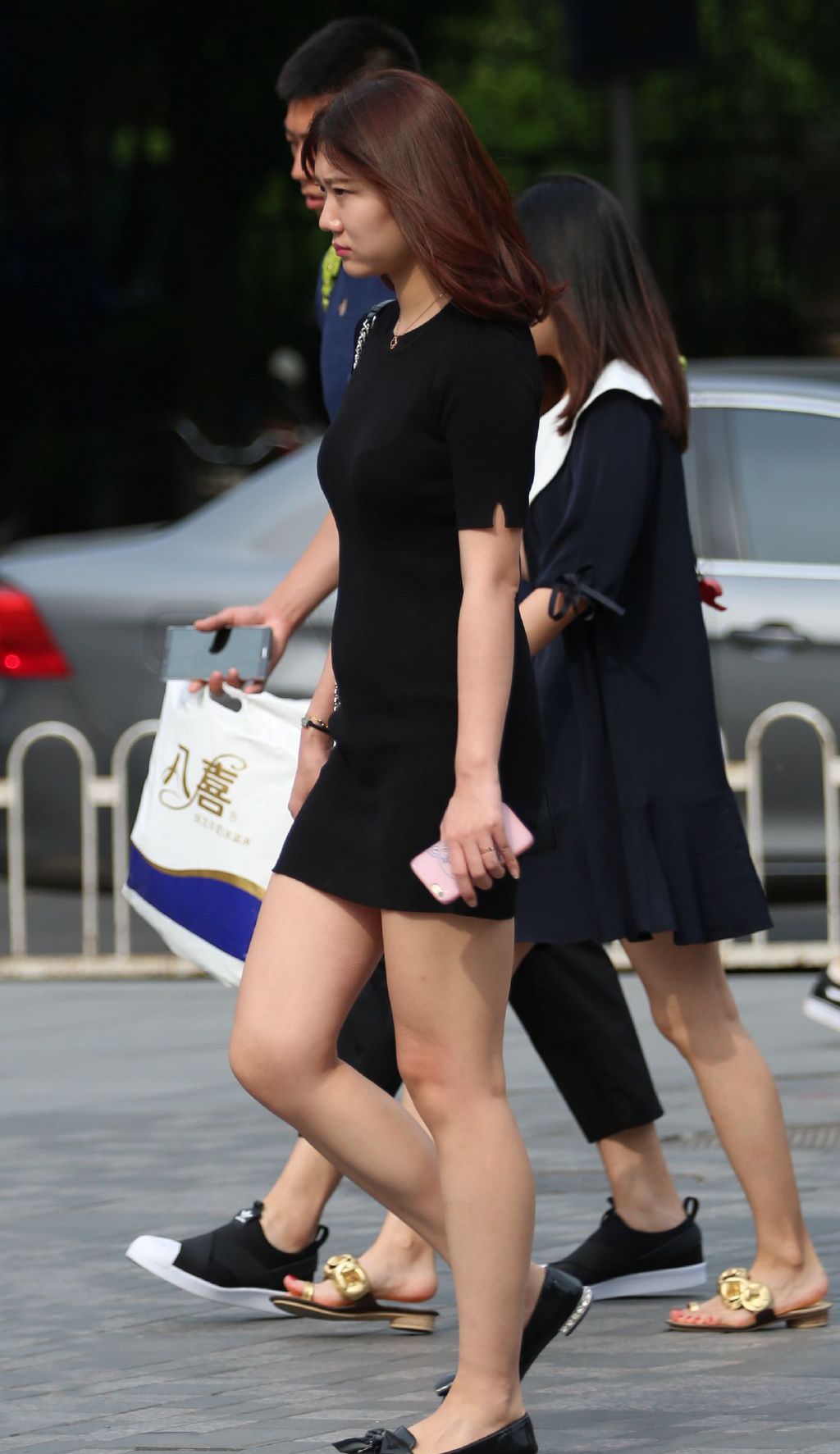 街拍极品少妇黑色连体短裙秀出白皙大长腿身材迷人