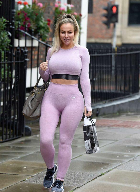 女星HollyHagan一袭紫色运动装亮相利物浦街头，手提购物袋返家