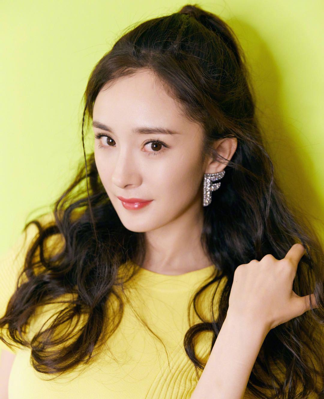 杨幂换新发型了,波浪大卷发扎成半马尾,一身"蜜蜂黄"美回18岁