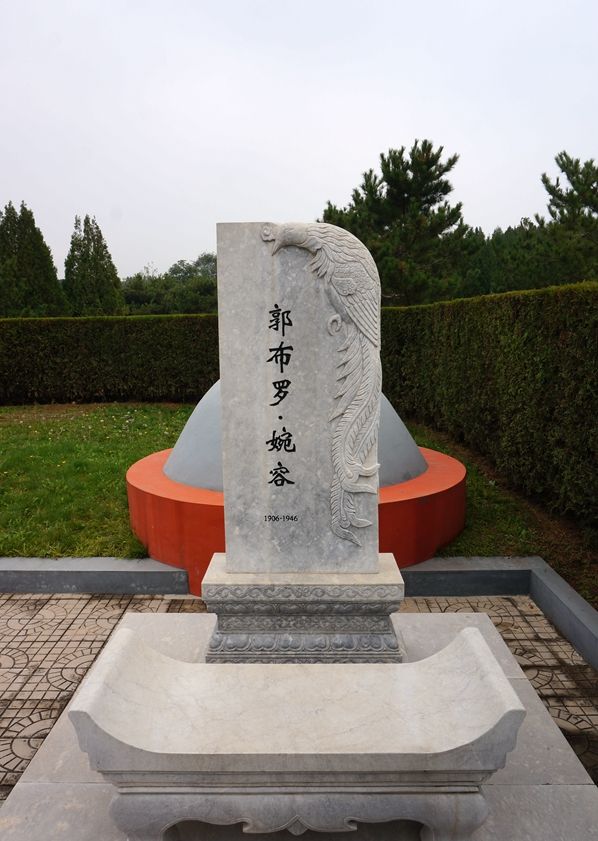 婉容皇后的衣冠冢,尸骨至今不知所踪,后人捧遗像墓前合影!