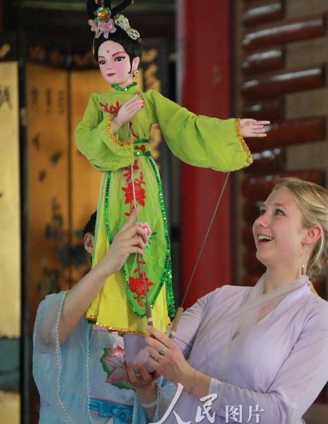 5月29日,在扬州瘦西湖风景区,法国学生体验扬州木偶戏.