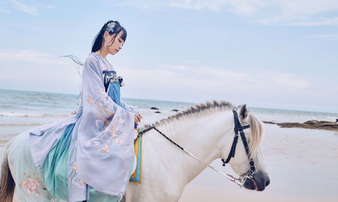 在海边的这位美丽的骑白马的汉服少女宛如仙子
