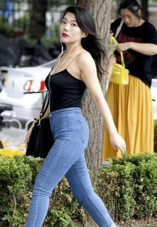 街拍:美女穿着牛仔裤紧致百搭,吊带上衣更是小巧迷人