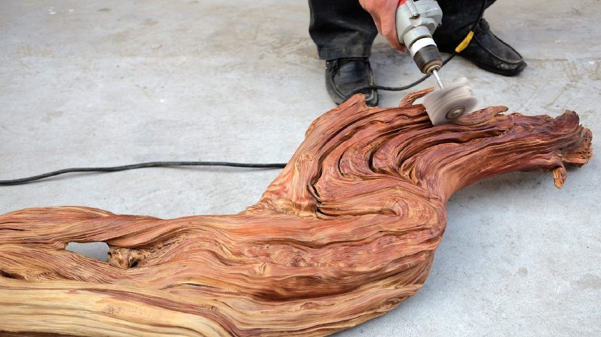 王建强师傅对要价2000多元已售出的崖柏根艺作品龙做最后打磨