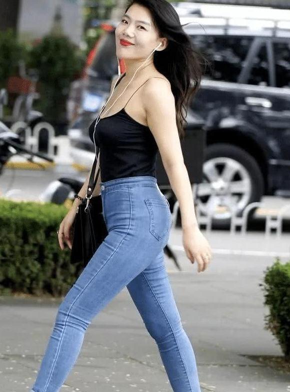 街拍:美女穿着牛仔裤紧致百搭,吊带上衣更是小巧迷人