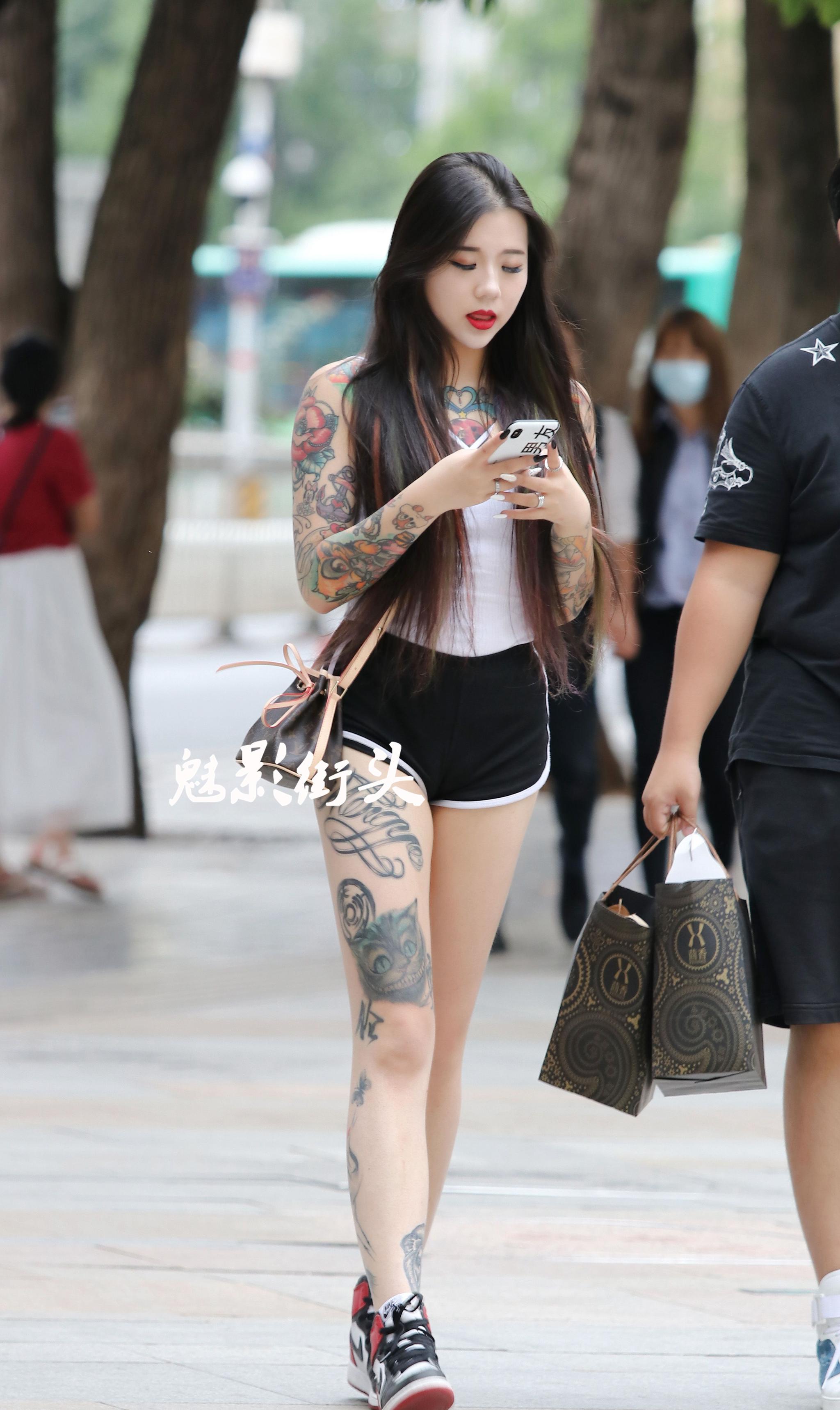 街拍白色吊带t恤搭短裤露出大面积纹身霸气十足很有时尚感