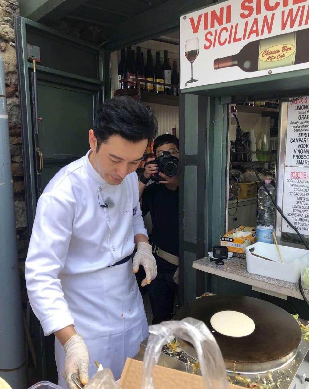 照片里路边的一个小摊,黄晓明身着厨师服,发型一丝不苟,正认真的摊