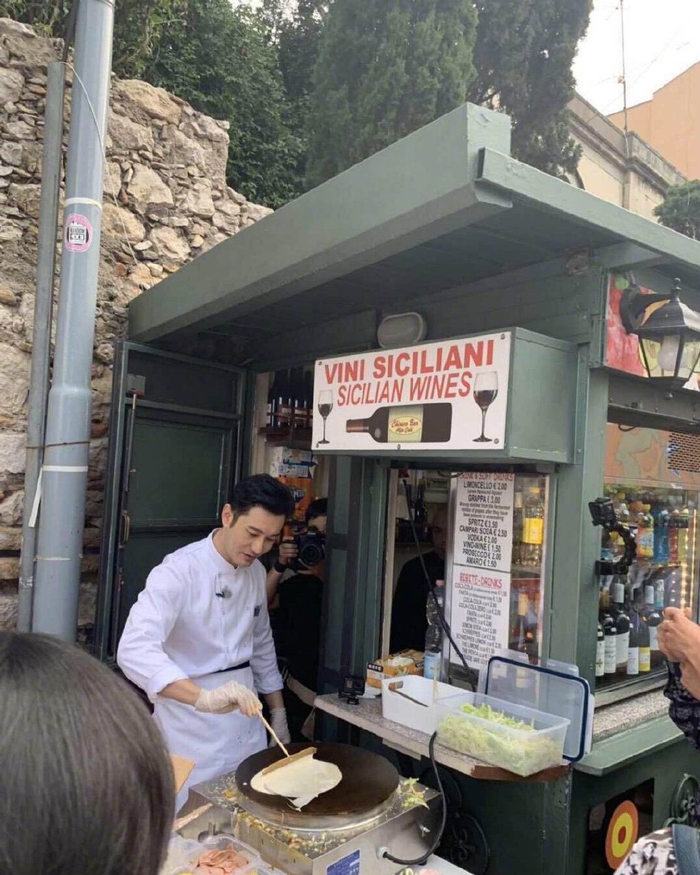 照片里路边的一个小摊,黄晓明身着厨师服,发型一丝不苟,正认真的摊