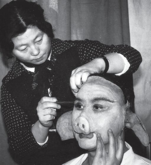 饰)装模作样地扮作老太医化妆师张兴华正在给八戒扮演者马德华化妆化