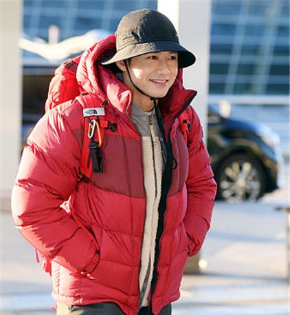 歌手吴钟赫穿大红色羽绒服包裹严实,机场背着双肩包活力满满