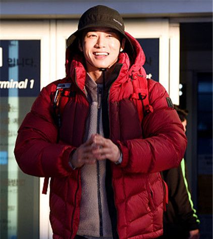 歌手吴钟赫穿大红色羽绒服包裹严实,机场背着双肩包活力满满