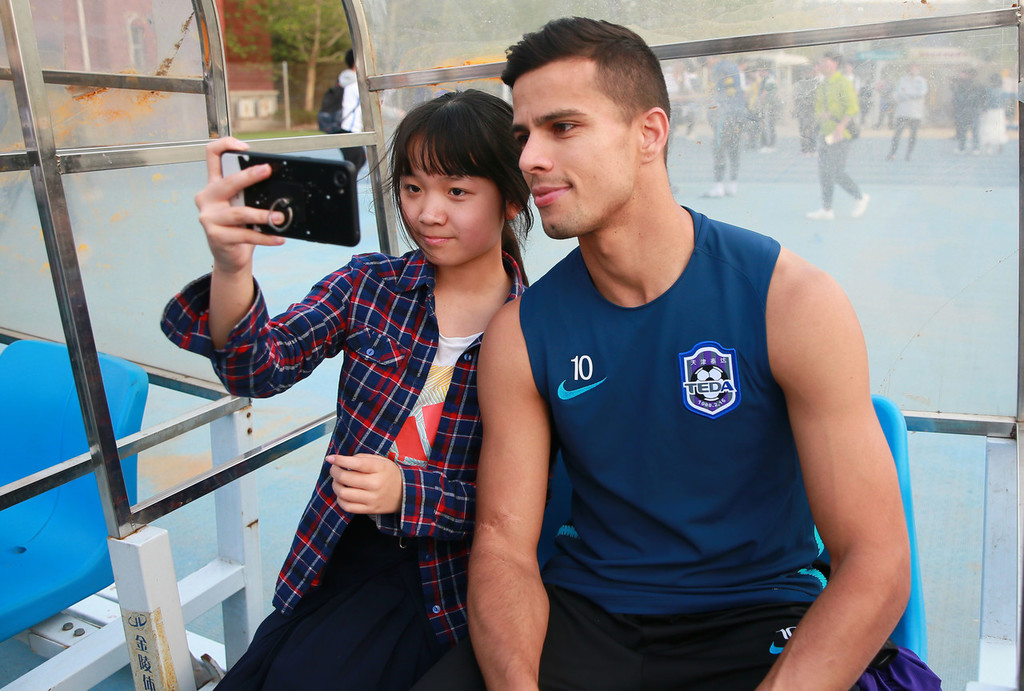 天津泰达公开训练人气颇高外援三叉戟与球迷欢乐合影