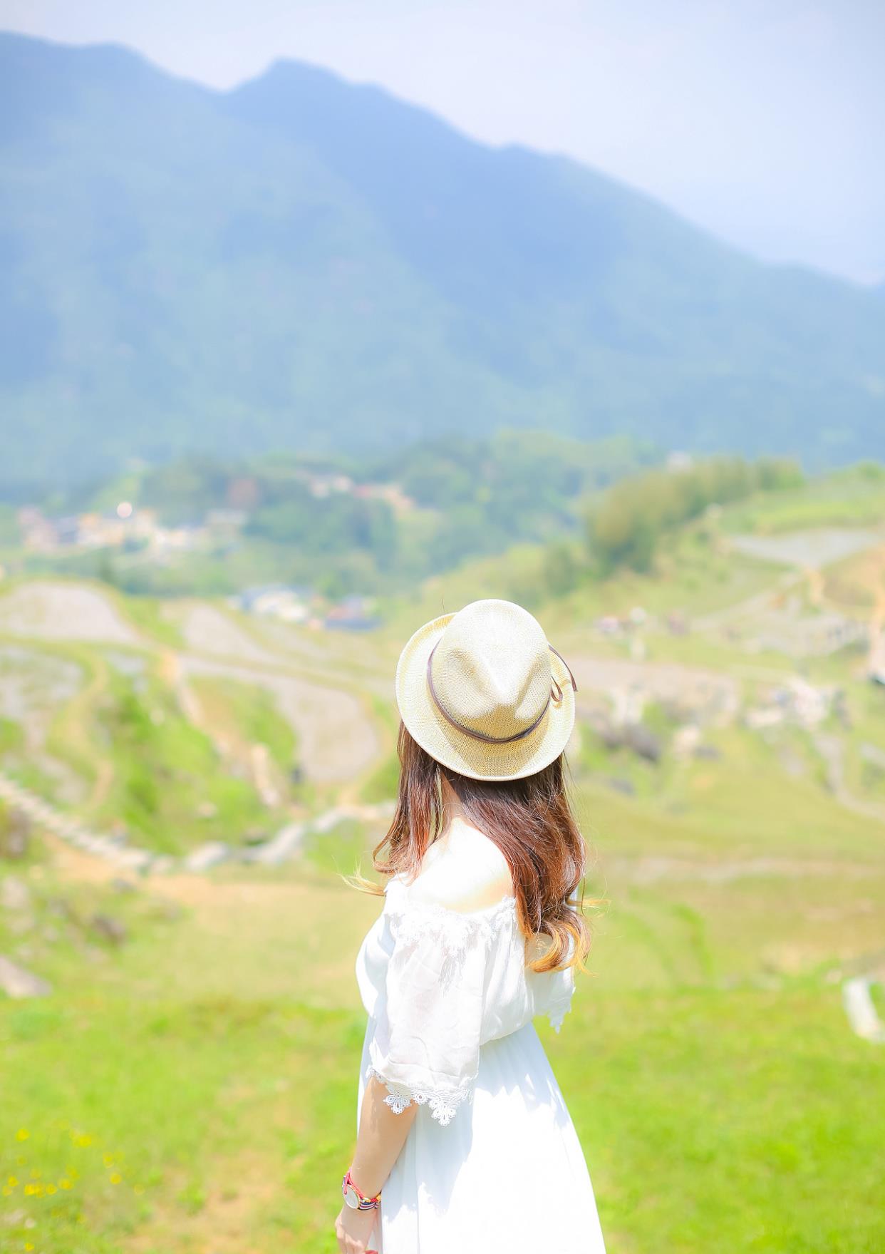 背对着相机的镜头,双手下垂,这样只拍出美女的背影和美丽的风景,给人