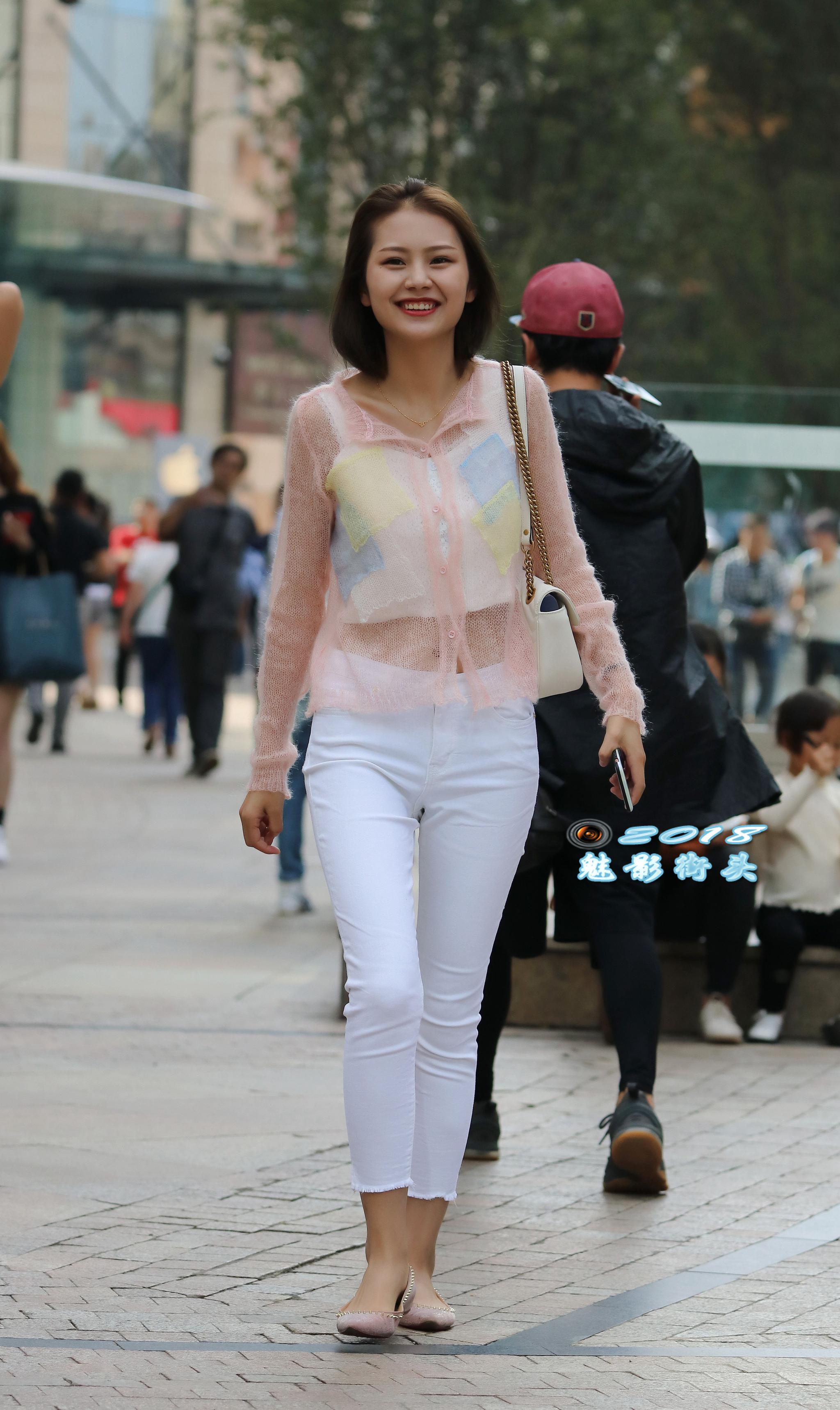 街拍:穿白色紧身裤的小姐姐气质不错,面对镜头露出自信的笑容|小姐姐