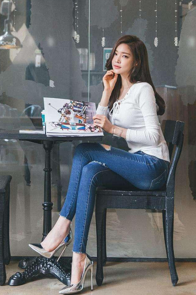 牛仔裤美女搭配白色背心手里拿着包包穿出淑女的气质