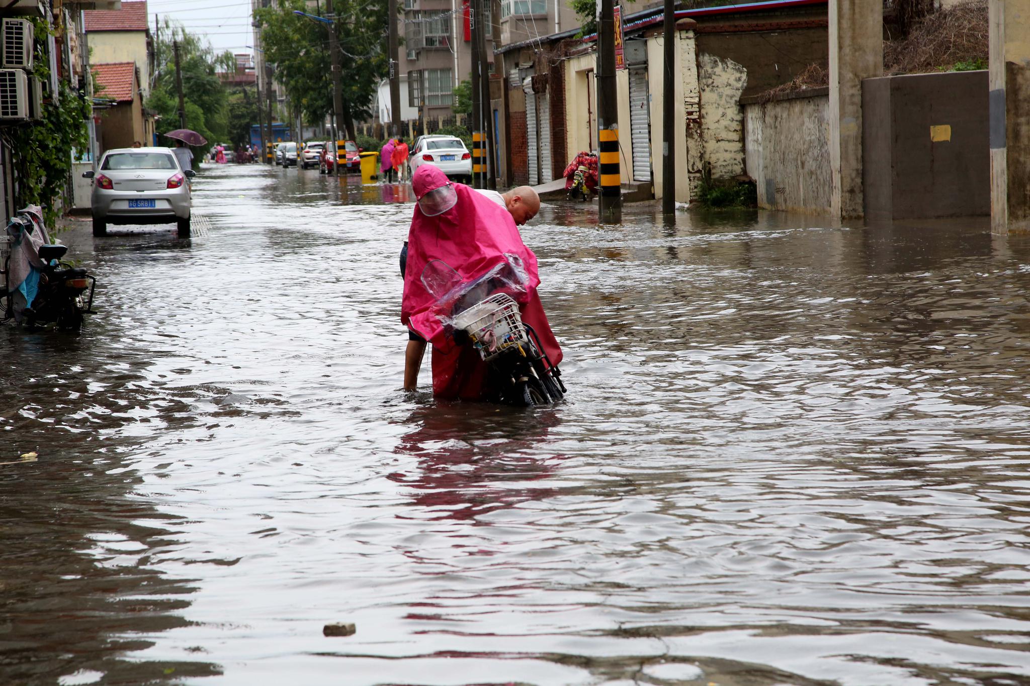 2019年7月6日,赣榆区市民在大雨中出行.