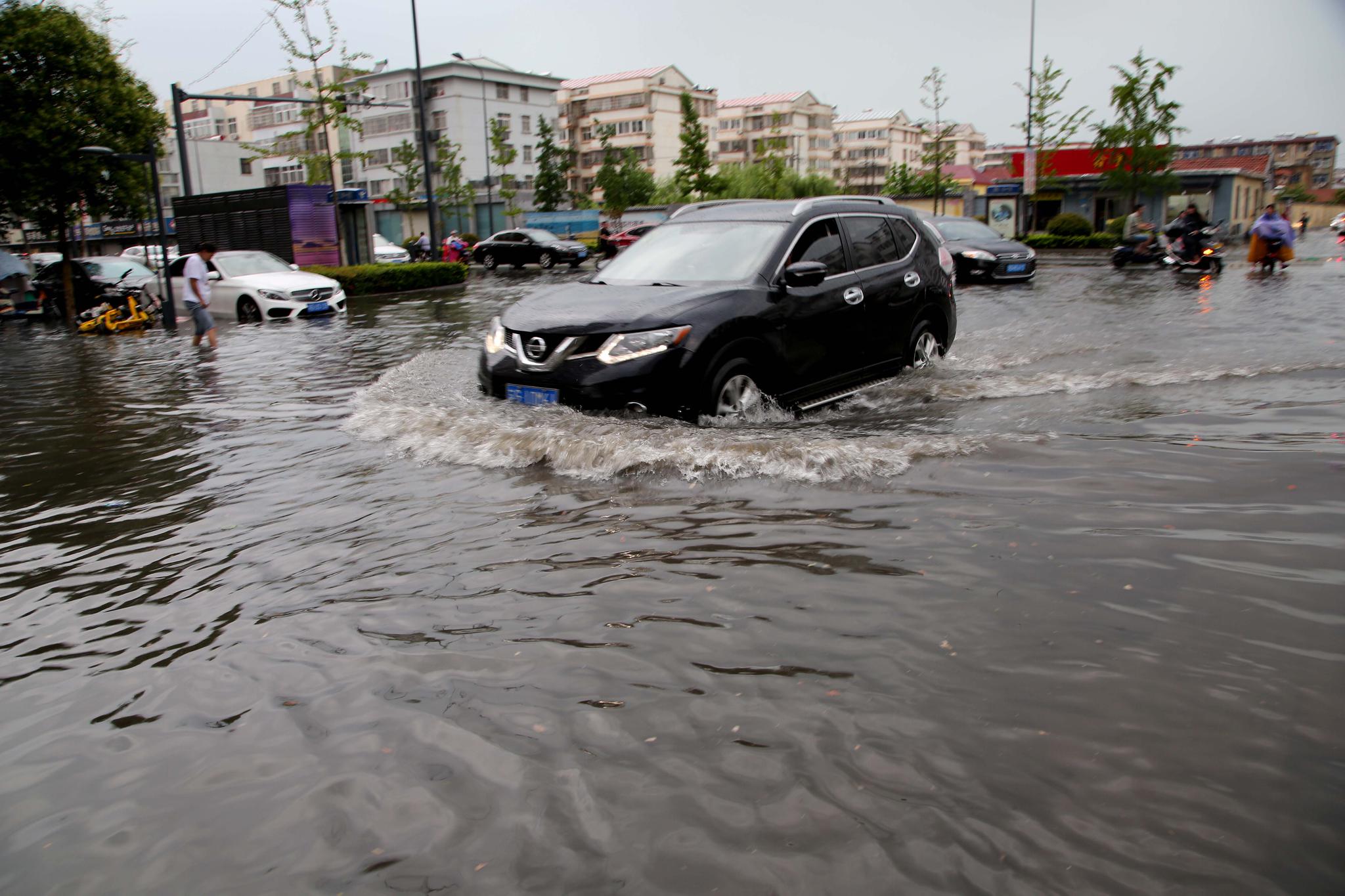 2019年7月6日,赣榆区市民在大雨中出行.