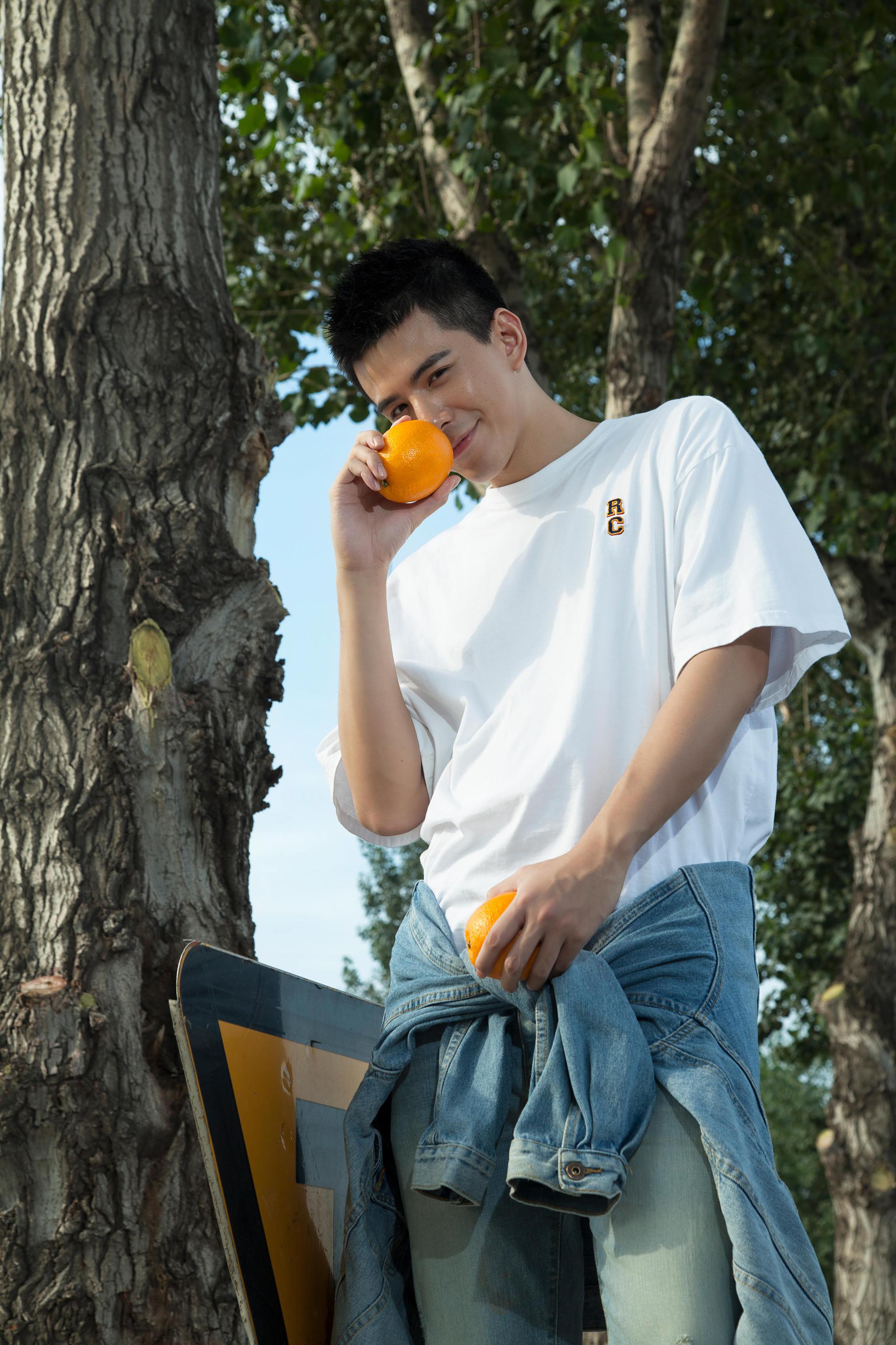 林柏睿秋日晒照路边食甜橙 白t牛仔裤画面清新