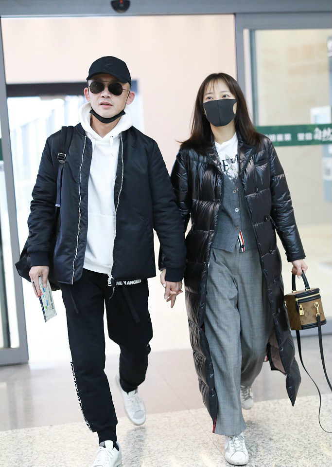 聂远和妻子秦子越手拉手现身机场,夫妻二人造型配一脸