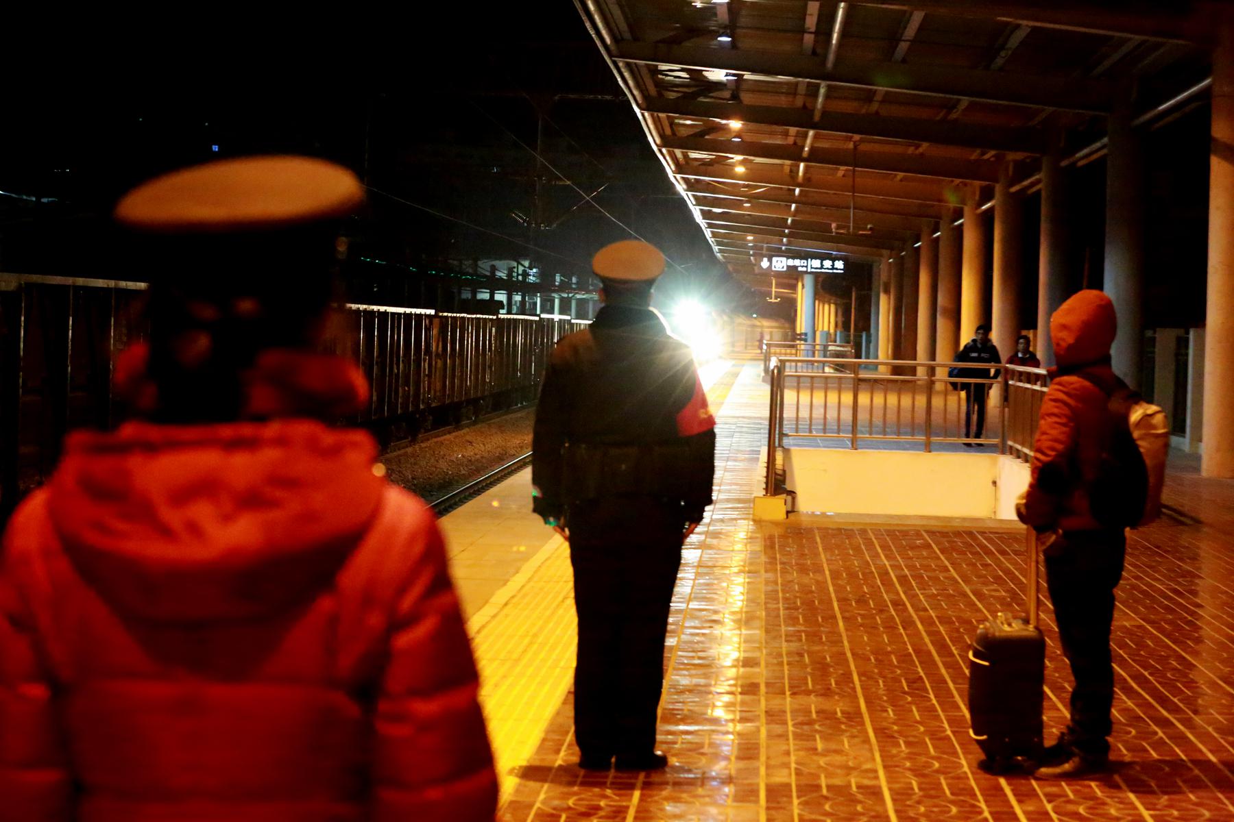 2019年12月31日晚站台上新警田磊和客运员等待列车驶进.