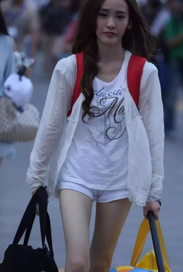 街拍美女:提着大包小包赶路的美女,这裤子也太紧了