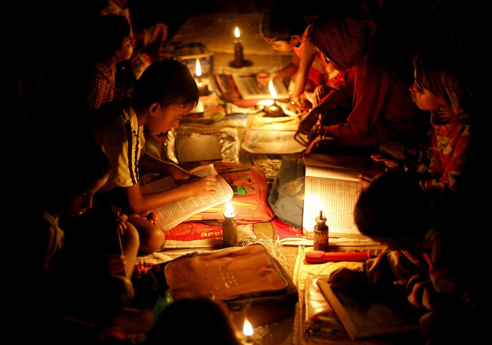 学生们在煤油灯下看书写字.