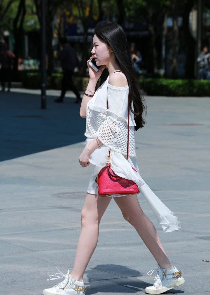 街拍小姐姐白色短裙配小白鞋长发飘飘尽显温婉文艺范