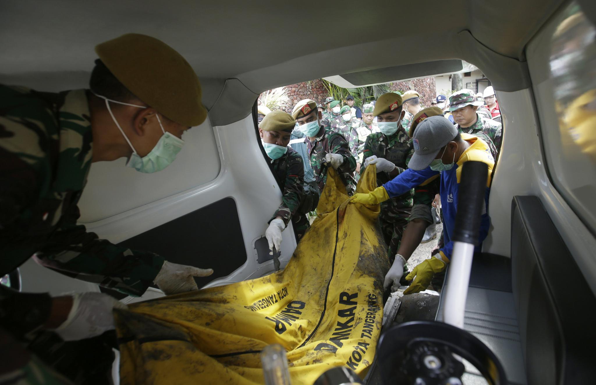 2018年12月24日,印度尼西亚搜救人员将海啸受害者的尸体装入救护车.