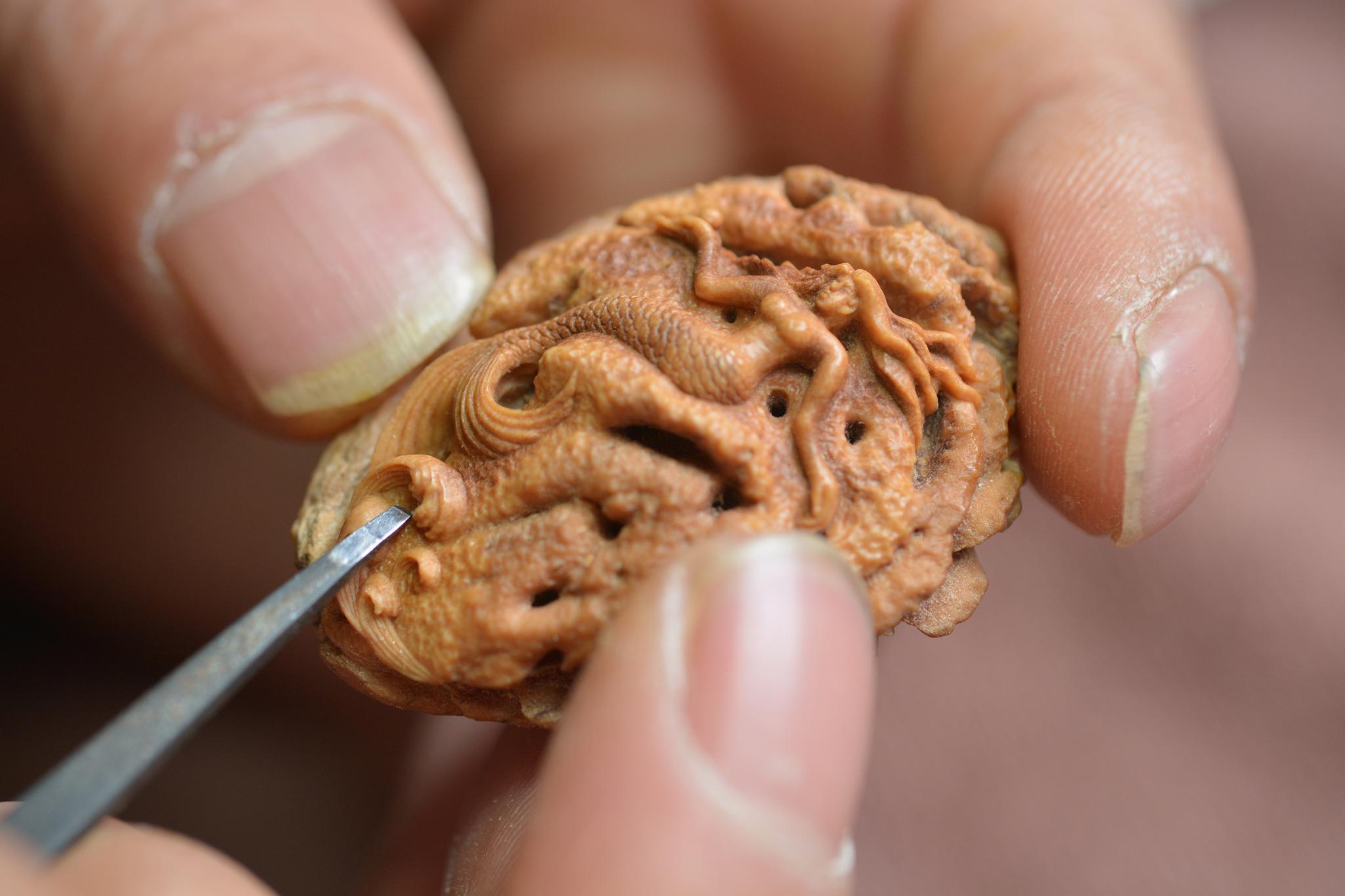 男子辞职专做桃核微雕,一件作品卖上万元,年收入保密