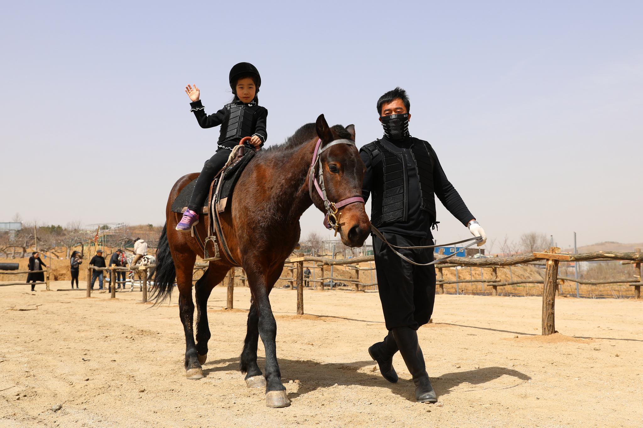 4月5日,在山东省荣成市,众多市民和游客来到郊区野外荡秋千,骑马,采摘