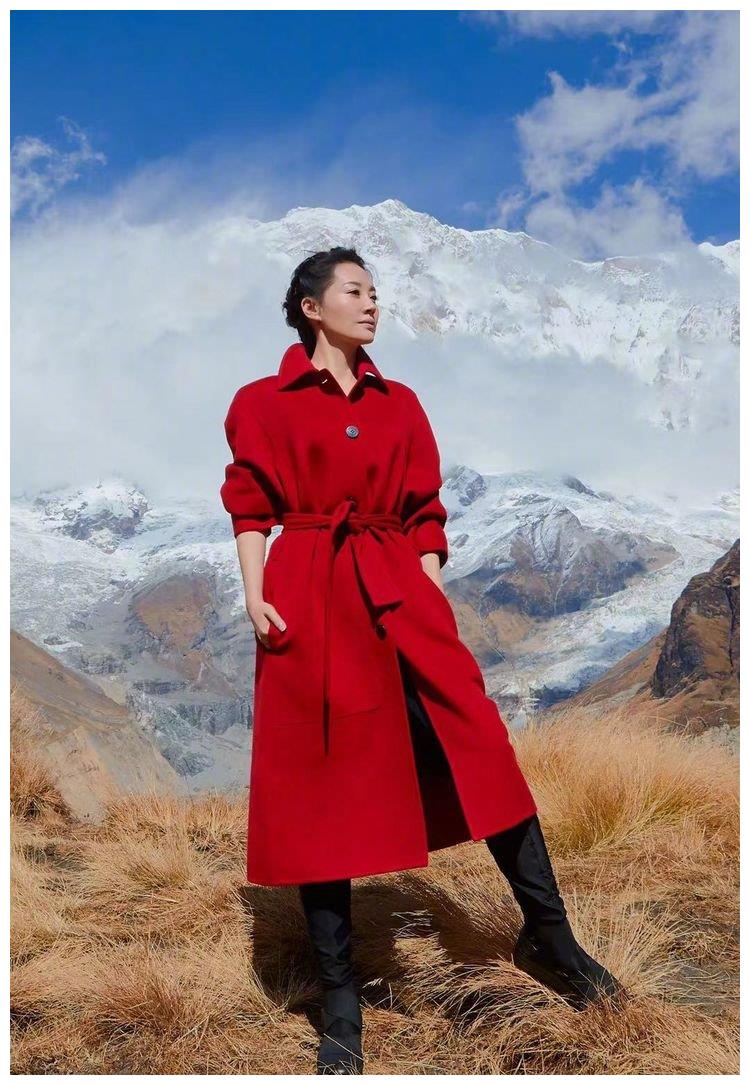为雪山顶添点"火",许晴大红风衣配长筒靴超霸气,50岁人比花娇