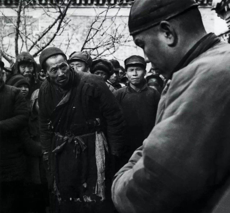 这是一张中国摄影大师齐观山拍摄于1950年北京郊区一个斗地主现场会上