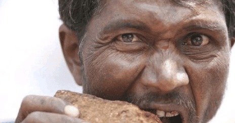 看样子是不太过瘾,大叔不仅吃砖头,还捡起了地上的沙子,就直接往嘴巴