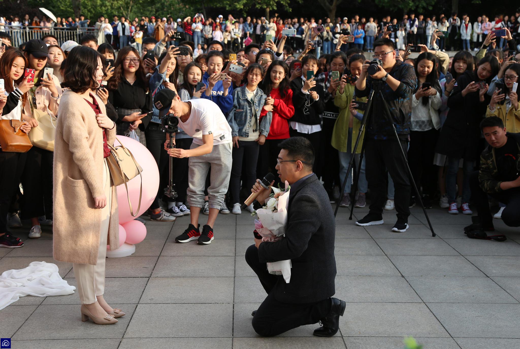 送鲜花,送钻戒,在众多学弟学妹的掌声中,顾晓单膝跪地完成了求婚仪式.