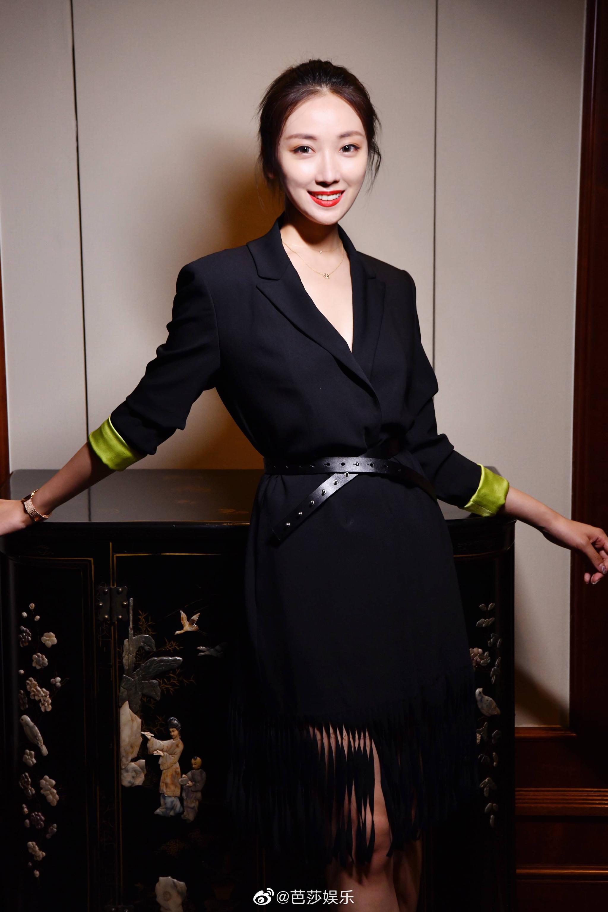 菅纫姿穿黑色西装干练优雅,绿色袖口青春活力,流苏点