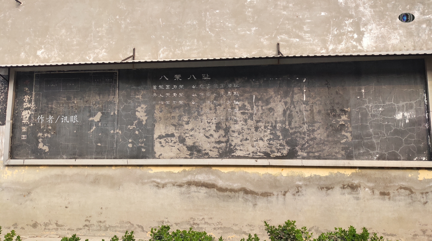 在一面龟裂的墙上有一块水泥黑板报,隐隐约约的还能看到上面的字,左边