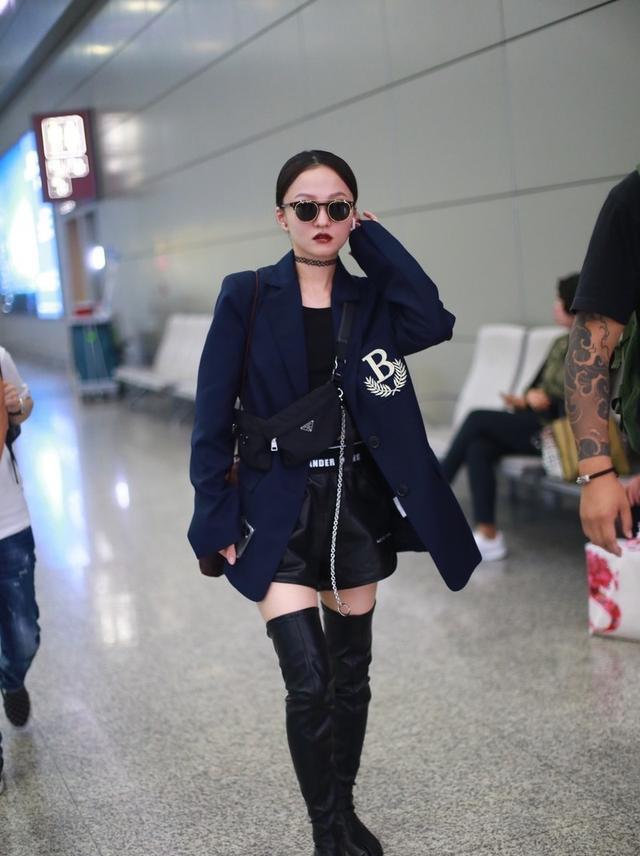 张韶涵身穿黑色束腰西装,脚踩长靴,尽显酷炫气质