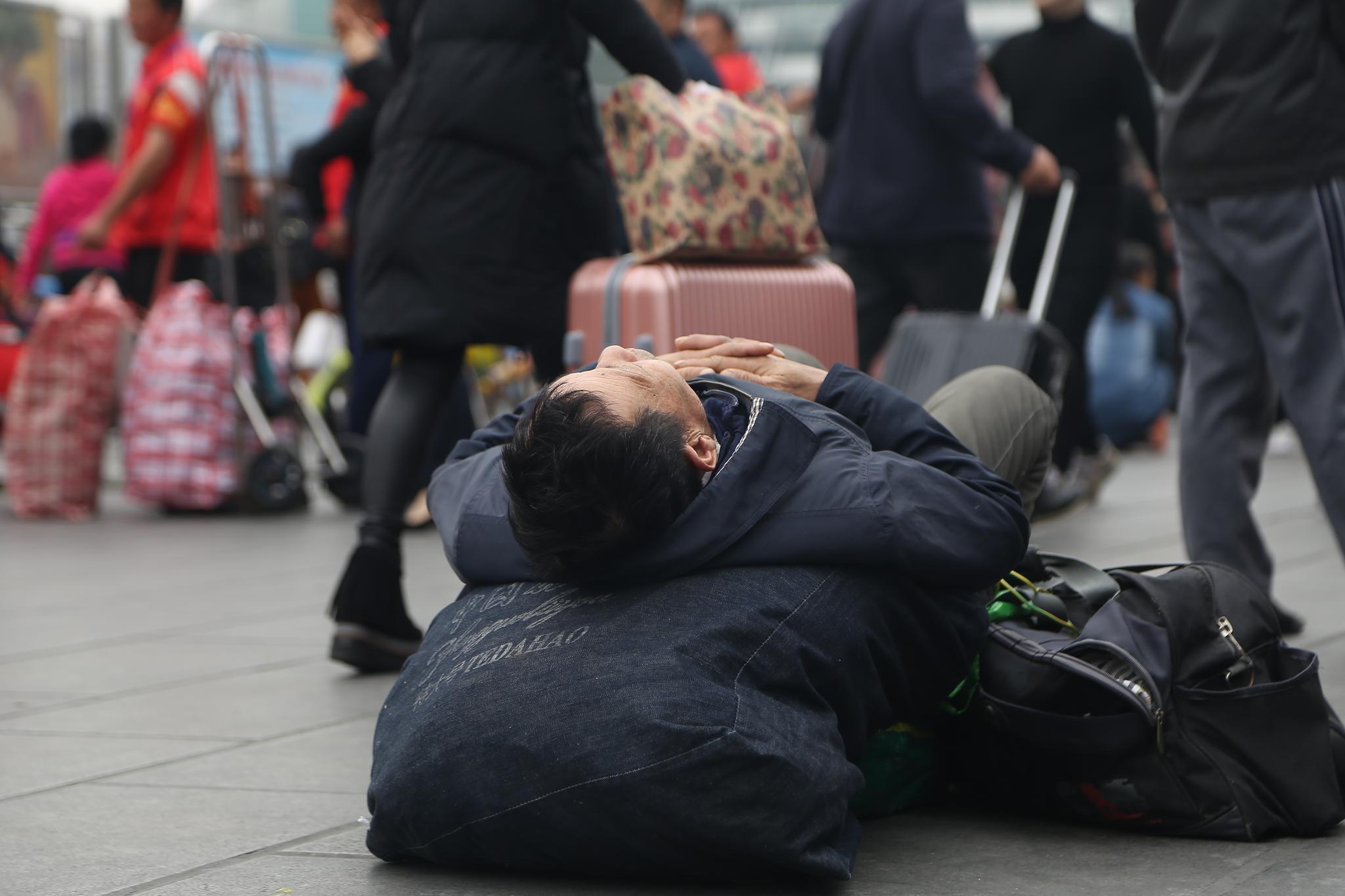 实拍广州火车站"最美"睡姿 疲惫到席地而睡瞬间入梦