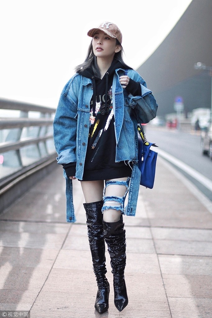 温岚头戴棒球帽美丽"冻"人 高筒靴破洞牛仔裤融为一体